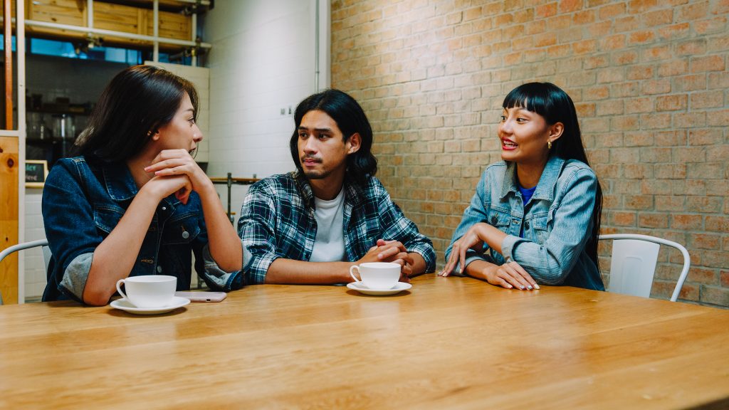 Group of happy young Asian friends having chatting and having coffee