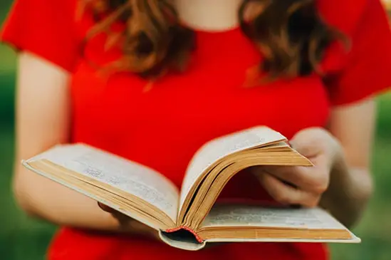 a woman in a red dress reading a book