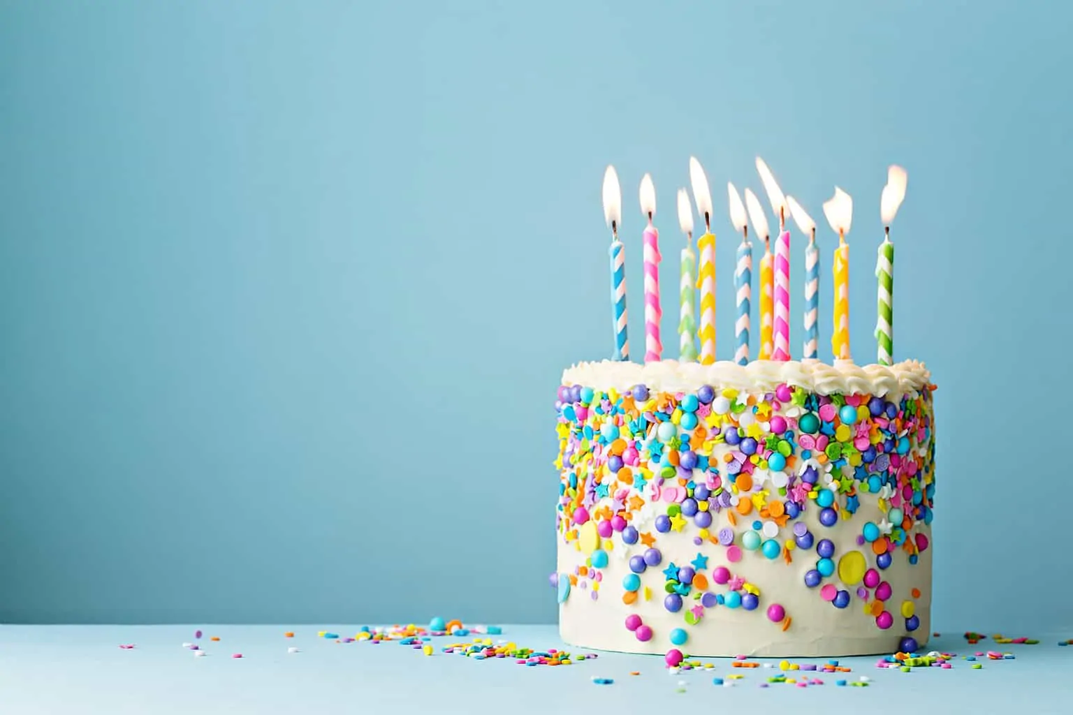 Birthday cake with lit candles on a table